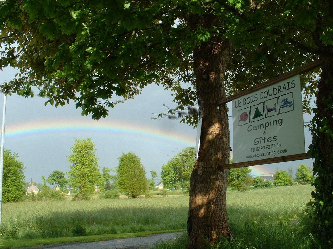 Le Bois Coudrais Camping & Gites over sign fixed between 2 trees at entrance of property 